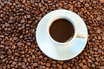 Close view of cup of coffee and roasted coffee beans ready to be