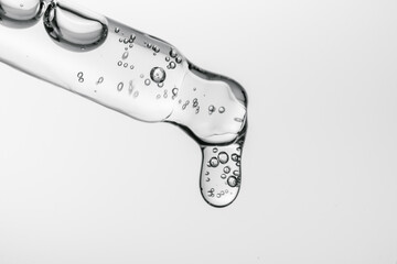 Transparent pipette with cosmetics on a white isolated background.