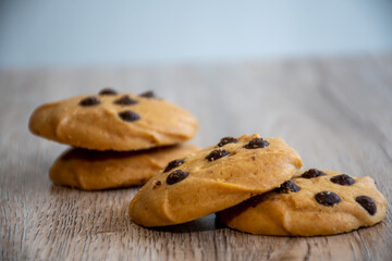 Classic chocolate chip cookies against wooden background. Concept of dessert, baking, and sweet food