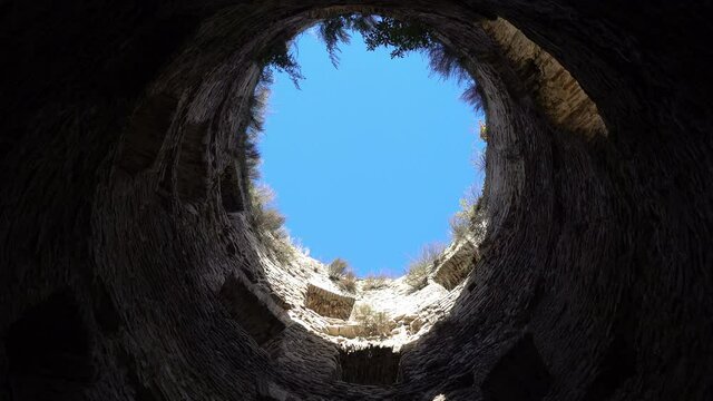 View from the bottom blue sky surrounded by stone walls,hope for freedom and happiness, tower of a medieval fortress in the evening. City of Izborsk, Pskov region, Russia.