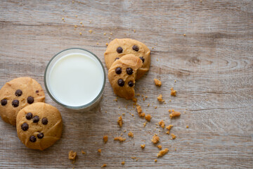 plate with chocolate chip cookies and a glass of milk on blurred background