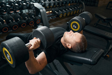 Male performing chest press exercise at gym