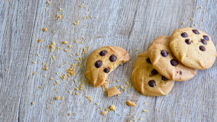 Classic chocolate chip cookies against wooden background. Concept of dessert, baking, and sweet food