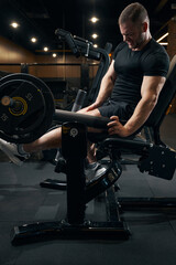 Fototapeta na wymiar Bodybuilder doing strength training exercise on fitness equipment
