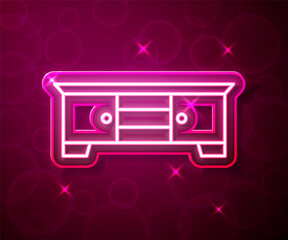 Glowing neon line TV table stand icon isolated on red background. Vector