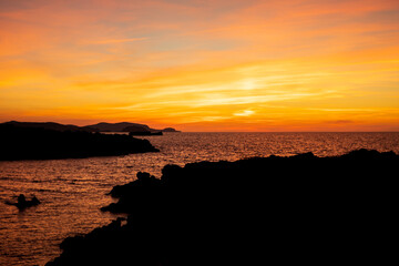 Cala Viola de Ponent, Menorca. September 2021. Magnificent sunset in the Mediterranean Sea. On one of the paradisaical beaches of the island of Menorca.
