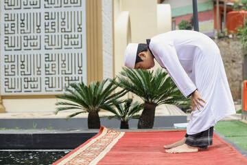 Side view a islamic boarding school student doing salat with rukuk posed or bend down