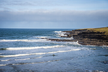 image of Atlantic ocean sea waves splashing with white foam against rocks, beach, rocky cliff, Kilcummin,mayo,ireland. Sea patterns.  Landscape