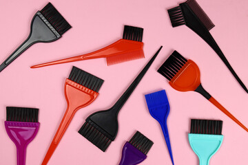 Background of hair coloring brushes on pink. Beauty salon or barbershop tools