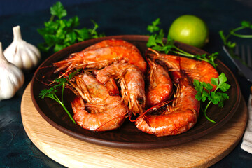 Red Langostino shrimps Prawns on a wooden board. Gray background. Top view. Copy space.