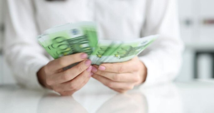 Businesswoman counts cash one hundred euro banknotes
