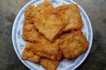 Tempeh fried with flour dough and placed in a round plate. Cheap food. One of the typical and favorite foods in Indonesia.
