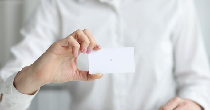 Businesswoman holds out white business card for dating