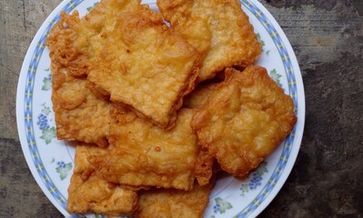 Tempeh fried with flour dough and placed in a round plate. Cheap food. One of the typical and favorite foods in Indonesia.