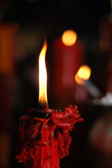 A red candle is lit in a Buddhist monastery