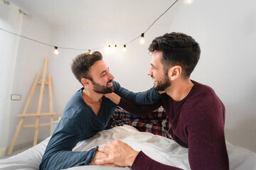 Happy gay couple having tender moments in bedroom
