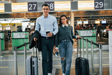 Walking forward. Young couple is in the airport together
