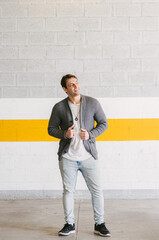 portrait of fashionable cool man on an industrial environment with hand on his jacket. vertical shot. High quality photo