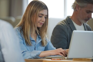 Obraz premium Young modern woman in smart casual wear working on laptop while spending time in the office