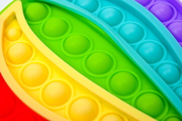 Rainbow colored bubble toy in the form of a balloon to relieve stress.