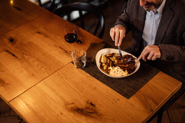 Closeup picture of a plate full of warm food, about to be eaten by an adult caucasian man.
