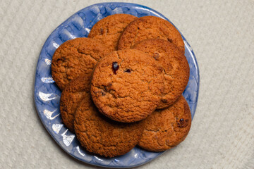 homemade oatmeal cookies lie on a blue plate against a white tablecloth