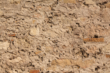 Beautiful texture of an old wall from orange stones with cracks