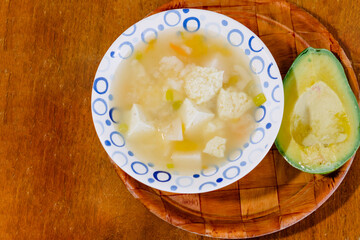 A bowl of Colombian mote de queso, thick yam soup with onion, garlic, peasant cheese cubes
