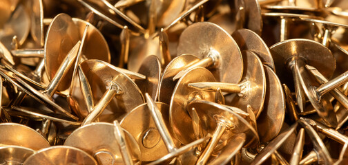Macro shooting of metal stationery buttons in copper, gold color.
