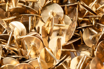 Macro shooting of metal stationery buttons in copper, gold color.