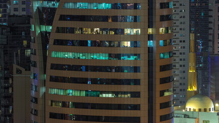Fototapeta na wymiar Mosque and skyscrapers in Barsha Heights district with glowing windows in office tower aerial night timelapse