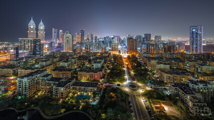 Fototapeta na wymiar Skyscrapers in Barsha Heights district and low rise buildings in Greens district aerial all night timelapse.