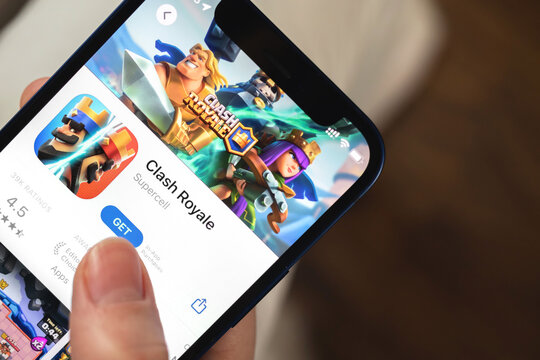 Clash Royale game app. Girl holding mobile phone with game and want to play. Popular mobile games concept photo