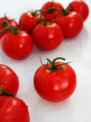 Closeup of a tomato in front of a group of tomatoes