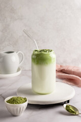 Dalgona matcha latte in glass, whipped grean tea with milk.