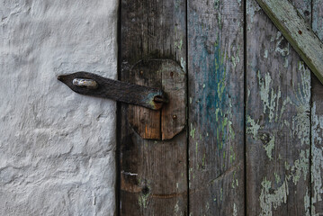 Old blue wooden door locked with metal padlock.