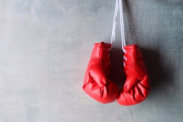 Red boxing gloves hang on wall with copy space for text. Retirement concept