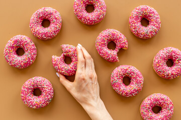 Bakery background of pink glazed donutes with sprinkles