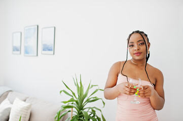 Fashionable photo of young beautiful romantic african american woman with glass of wine, wearing...