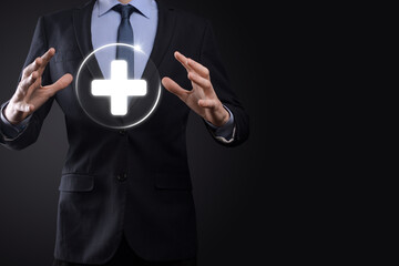 Businessman hold virtual plus medical network connection icons. Covid-19 pandemic develop people awareness and spread attention on their healthcare.