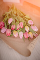 A bouquet of colorful spring tulips wrapped in a craft paper