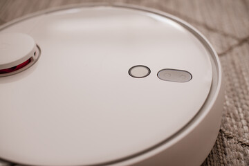 White robot vacuum cleaner on the floor in interior