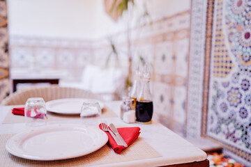 Oriental hospitality. Traveling by Morocco. Relaxing in festive moroccan traditional riad interior in medina. Table setting.