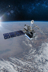 Cargo space craft and Earth planet. Dark background. Sci-fi wallpaper.Space Station Orbiting Earth.Space ship. Space art wallpaper.Solar Observatory.Elements of this image furnished by NASA. © Ivan