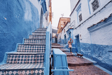 Traveling young woman on the street in medina of blue town Chefchaouen, Morocco.