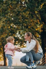 Mother with baby girl in autumnal park