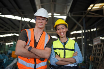 Portrait of male and female engineers working in the metalwork industry. Technical working with lathe machine at factory facility