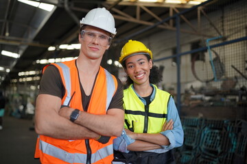 Portrait of male and female engineers working in the metalwork industry. Technical working with lathe machine at factory facility