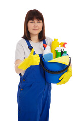 housework and cleaning concept - portrait of young female cleaner in blue uniform and yellow gloves holding bucket with cleaning equipment and thumbs up isolated on white