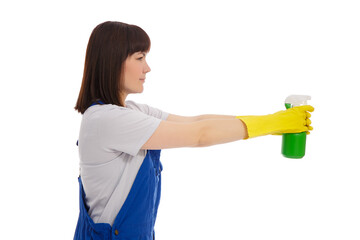 side view of young female cleaner in blue uniform holding detergent spray isolated on white